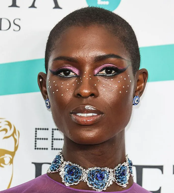 jodie turner smith baftas red carpet face gems pink eyeshadow black liner mascara lipstick