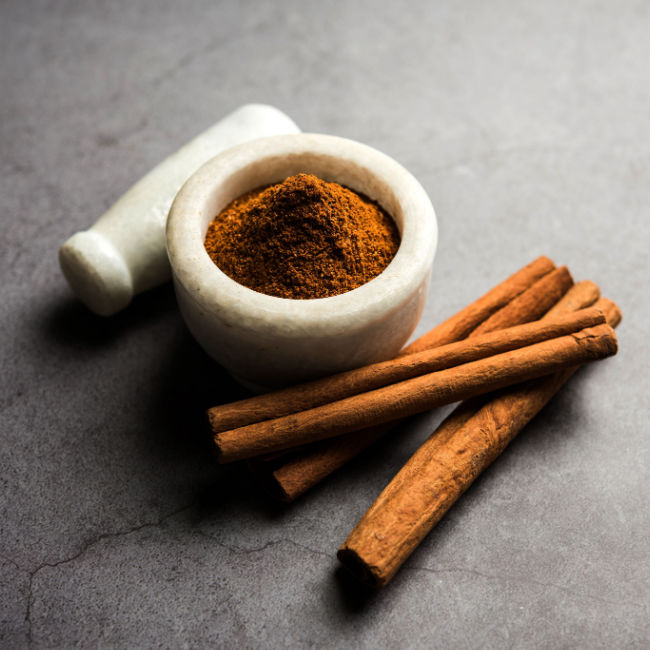 cinnamon sticks beside small bowl of ground cinnamon