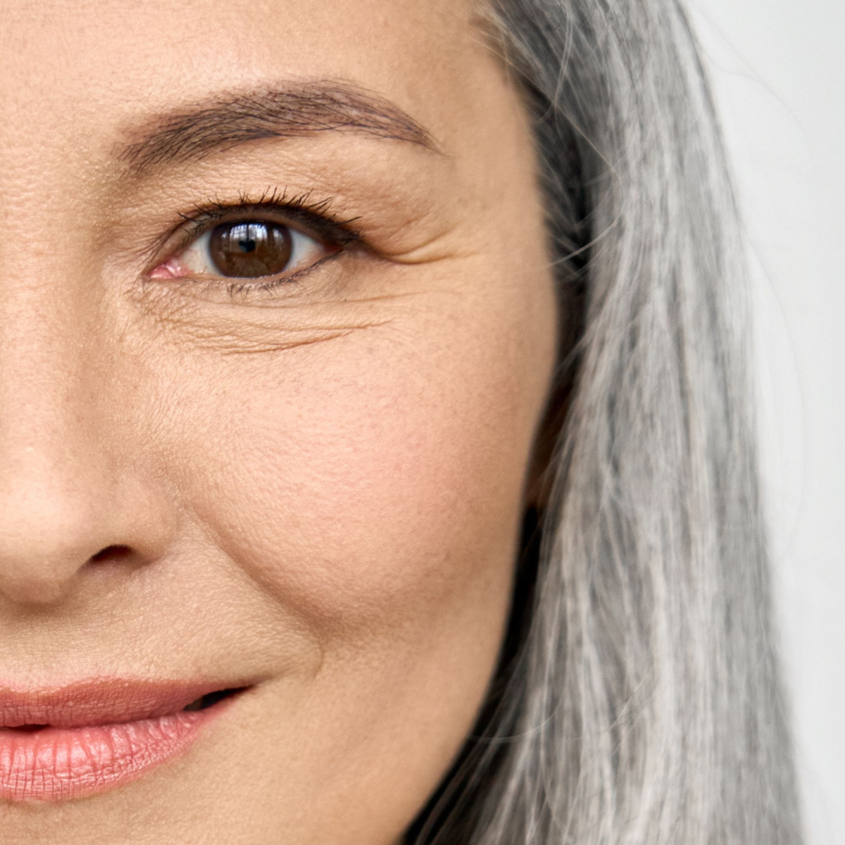 close up aging eyes sagging skin eyelashes under-eye wrinkles crow's feet gray hair