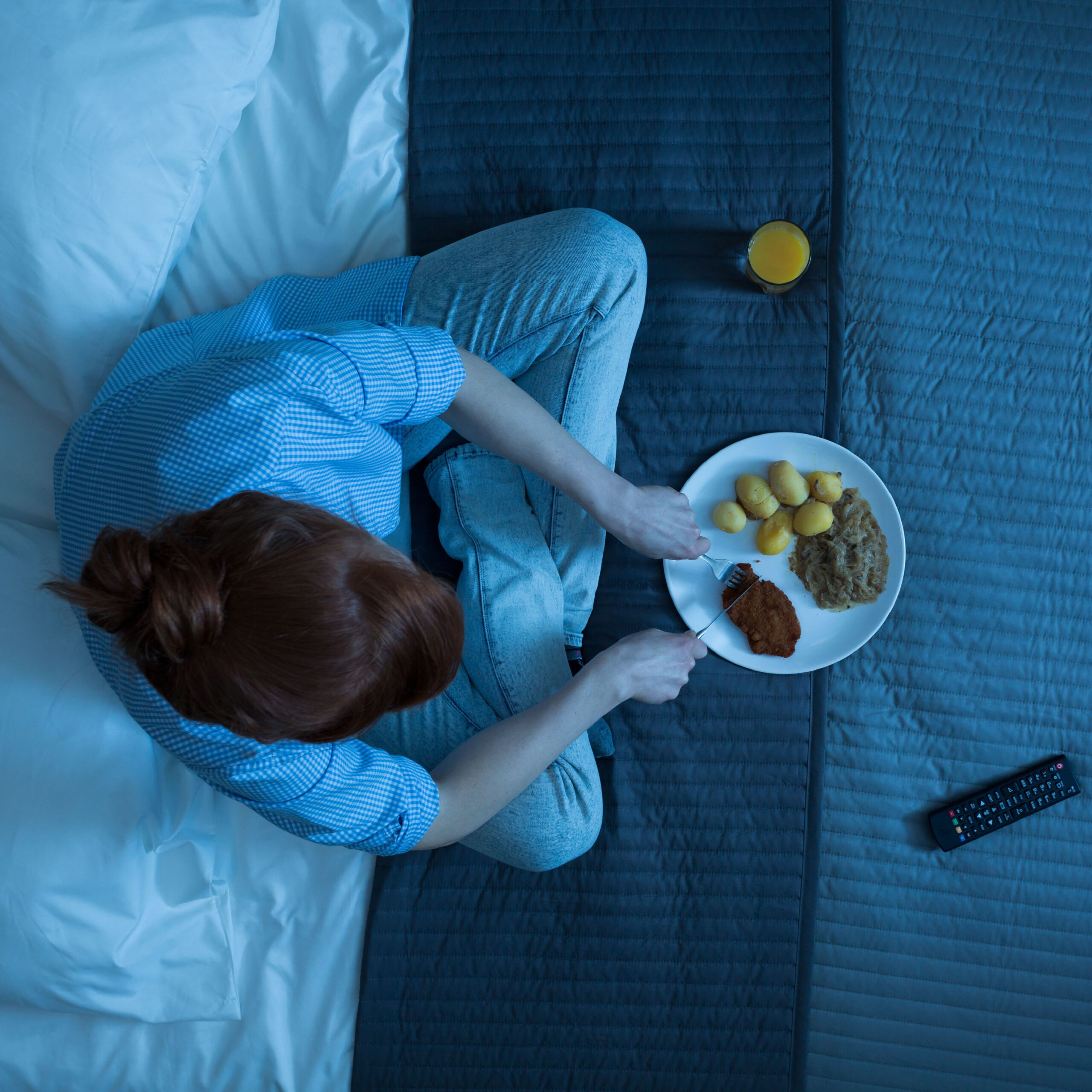 woman eating dinner in bed