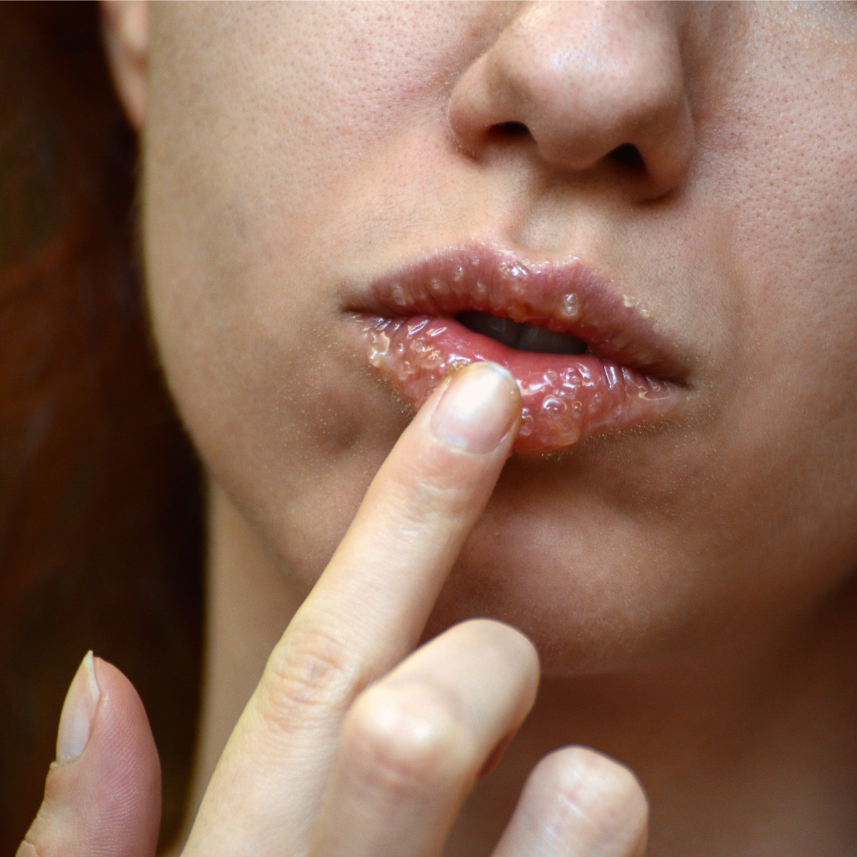 homemade exfoliating lip scrub woman applying product to lips with index finger
