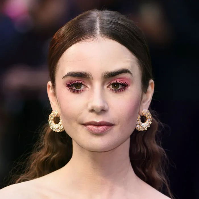 lily collins pink eyeshadow red carpet beauty makeup look brown hair gold hoop earrings