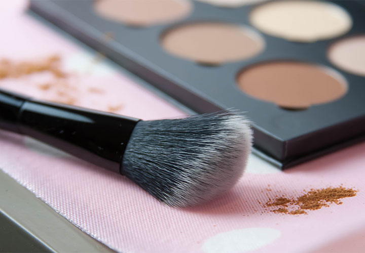 Makeup brush next to contour palette