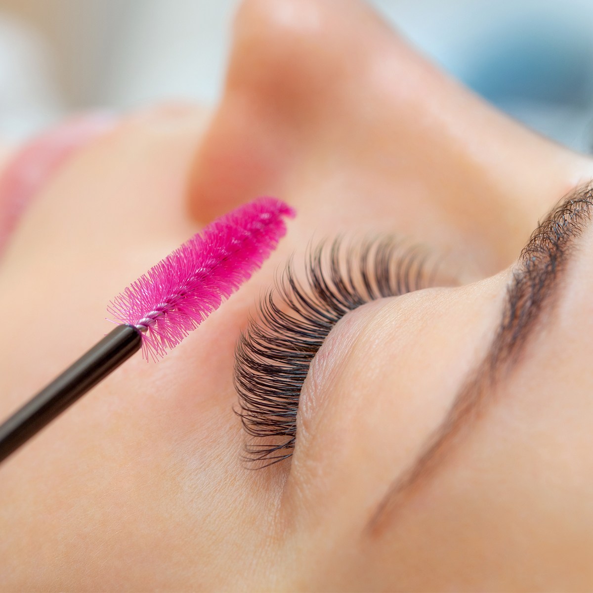 eyelashes pink cosmetic wand brushing lashes in salon