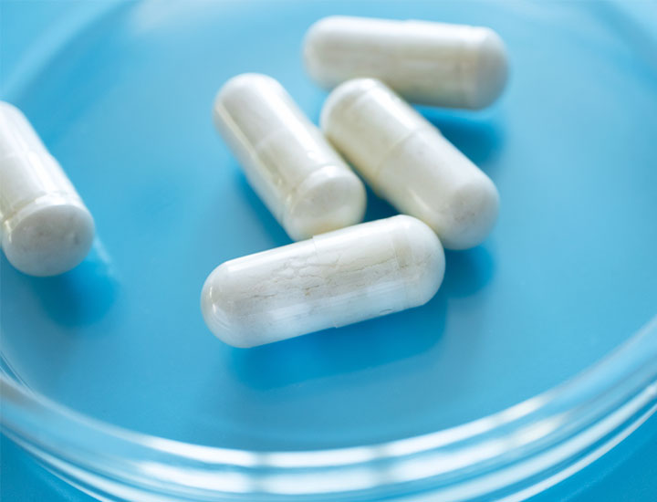 White probiotic supplement on a blue background