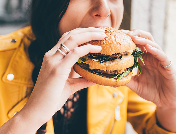 Woman eating a double cheeseburger