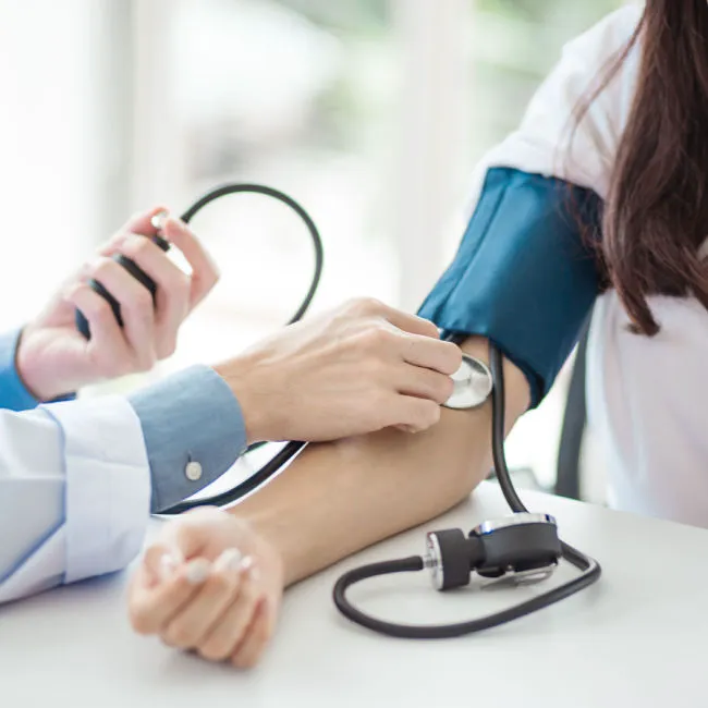 woman having blood pressure checked by doctor