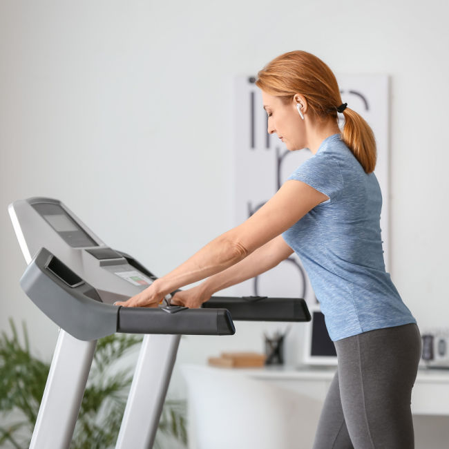 woman walking on treadmill at home