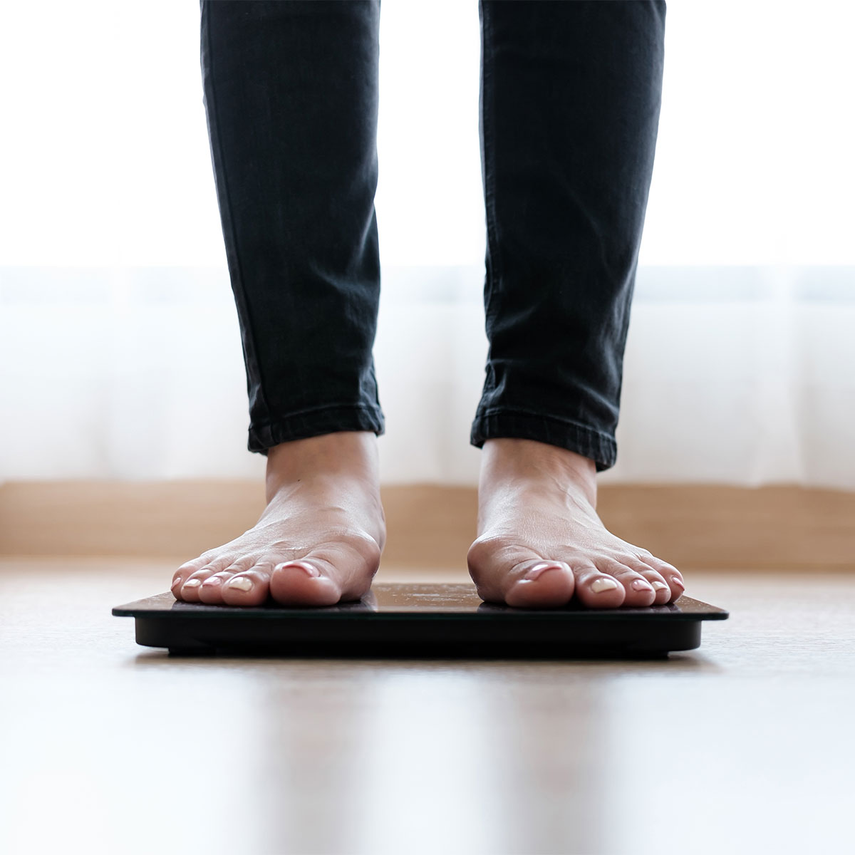woman standing on scale with bare feet