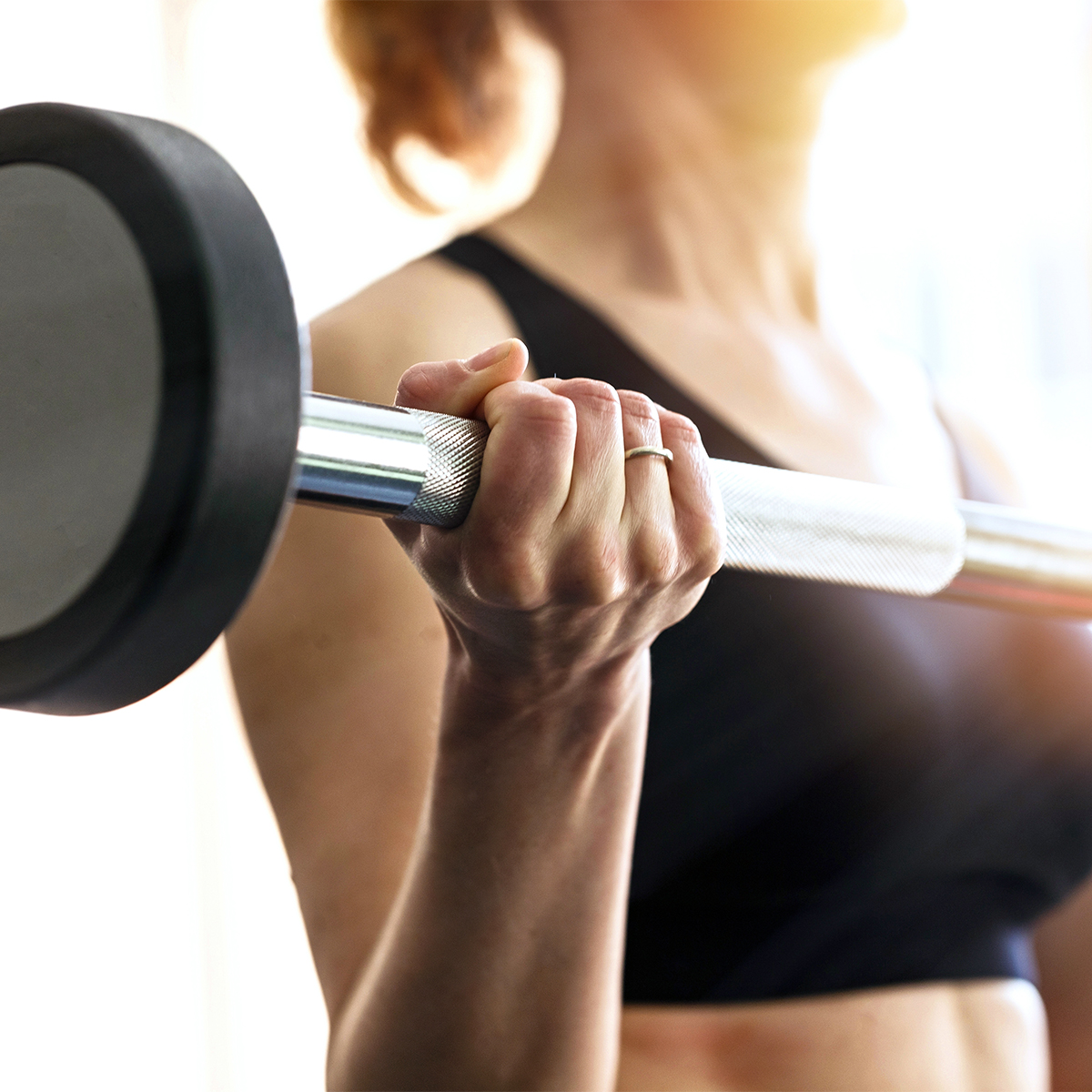 woman strength training with barbell