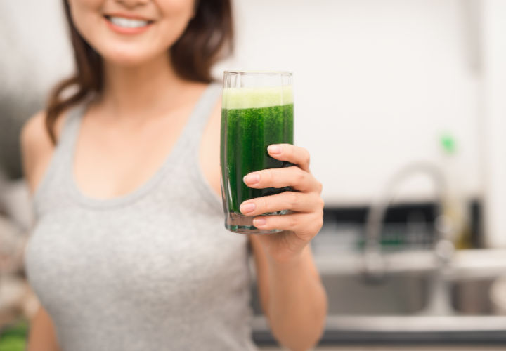 Woman holding green juice