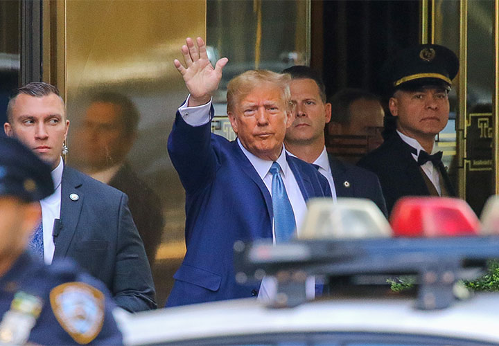 Donald Trump waving while exiting Trump Tower
