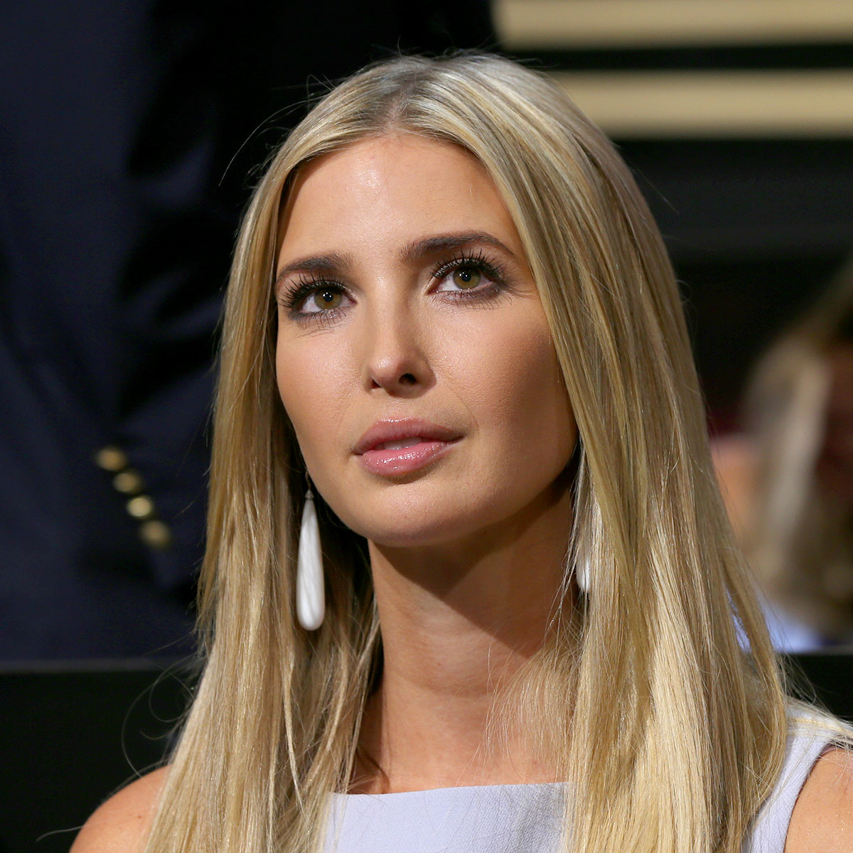 ivanka trump headshot blonde hair dangly earrings blue top