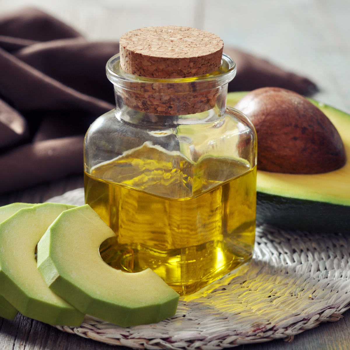avocado oil isolated on table sliced avocados glass bottle chopped