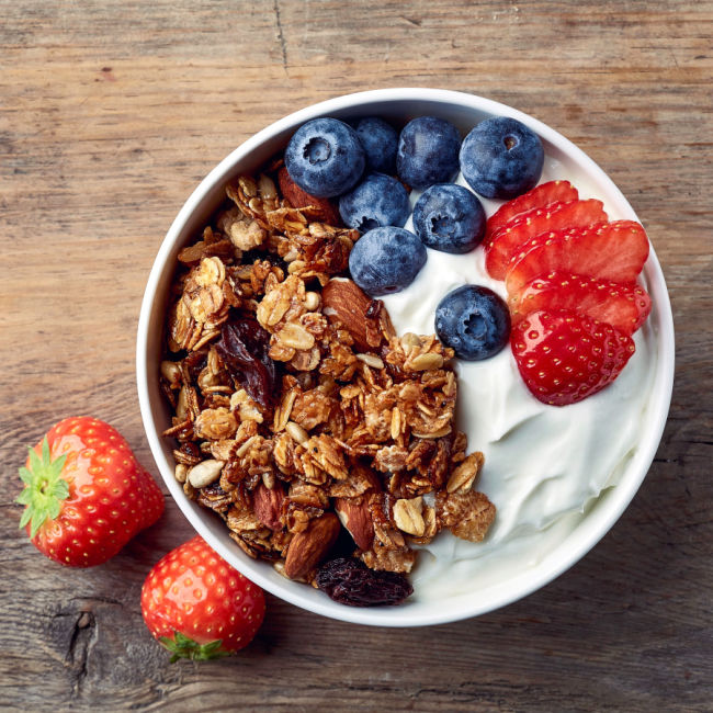 greek yogurt topped with granola, strawberries, and blueberries