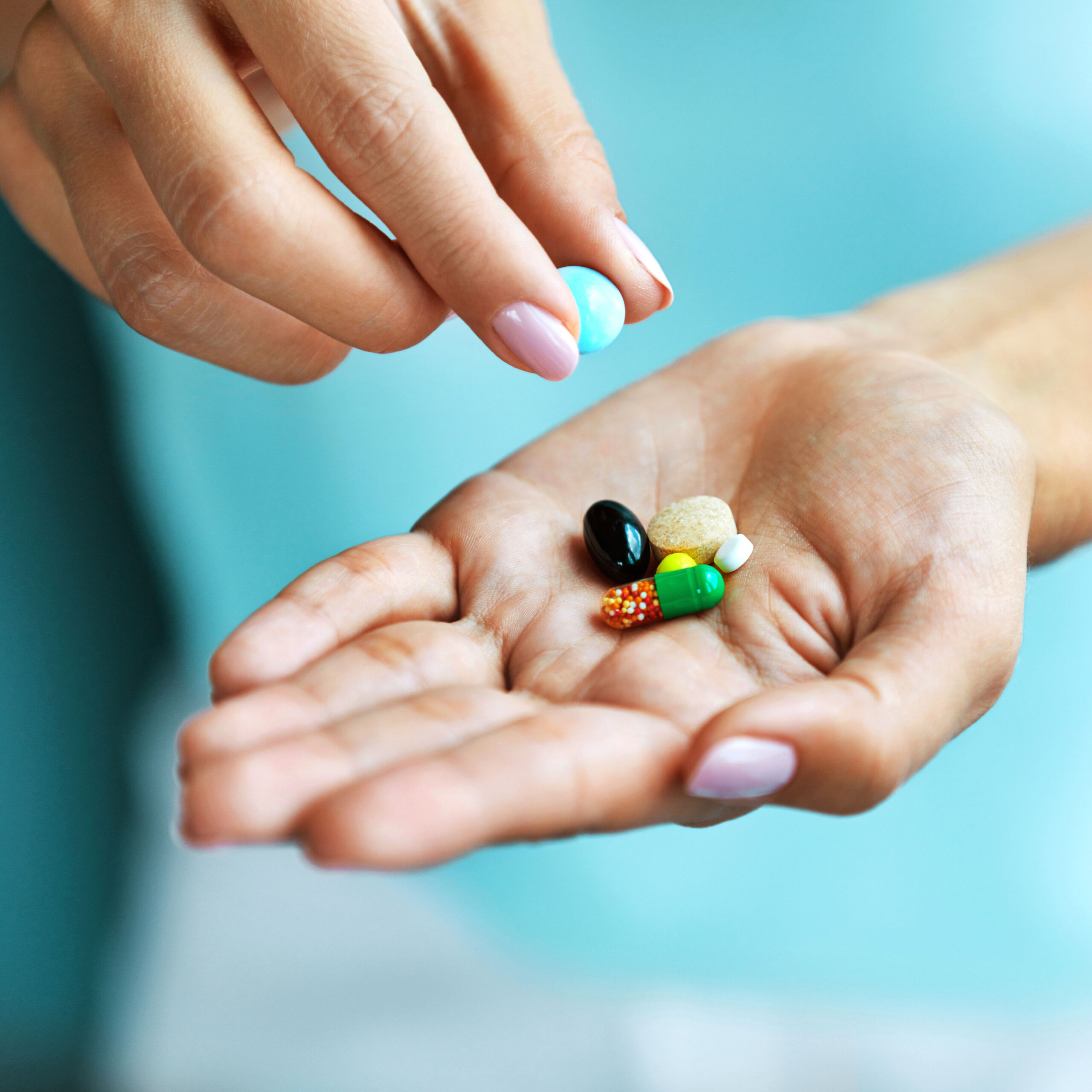 woman with handful of supplements