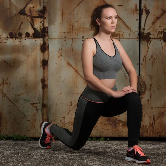 woman in athletic clothes stretching hip flexors