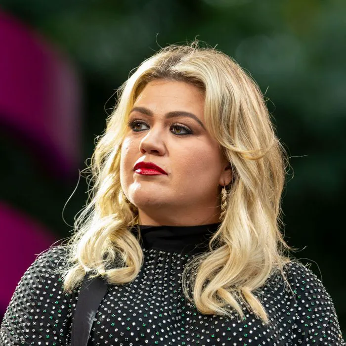 kelly clarkson upset gray top outdoor event blonde hair red lipstick
