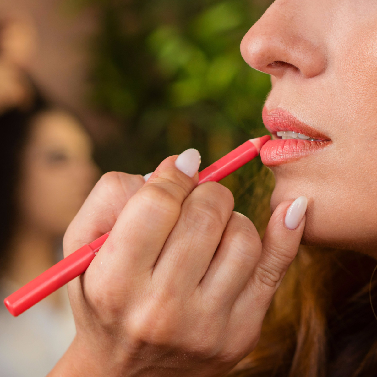 makeup artist applying natural lip liner pencil to client salon