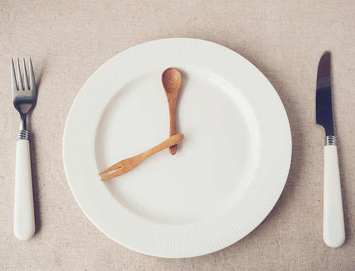 Concept of skipping meals empty plate clock