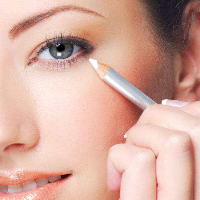 woman applying white eyeliner pencil to bottom waterline lashline