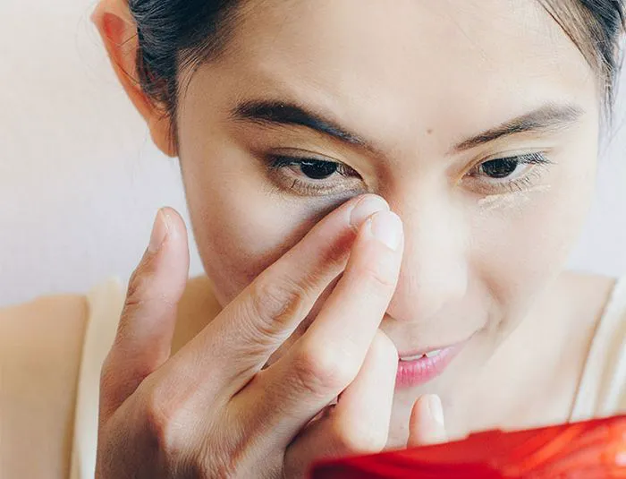 woman-applying-cream-under-eyes