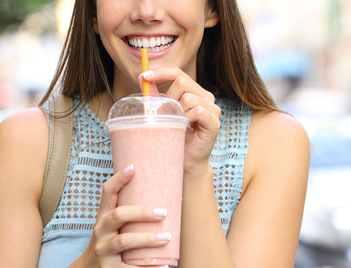 Woman drinking a pink smoothie