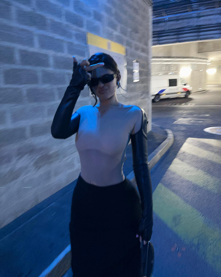 kylie jenner posing parking garage sheer top black skirt black sunglasses
