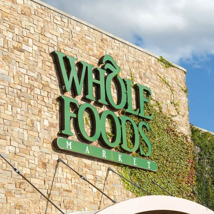 whole foods market green lettering storefront blue sky background