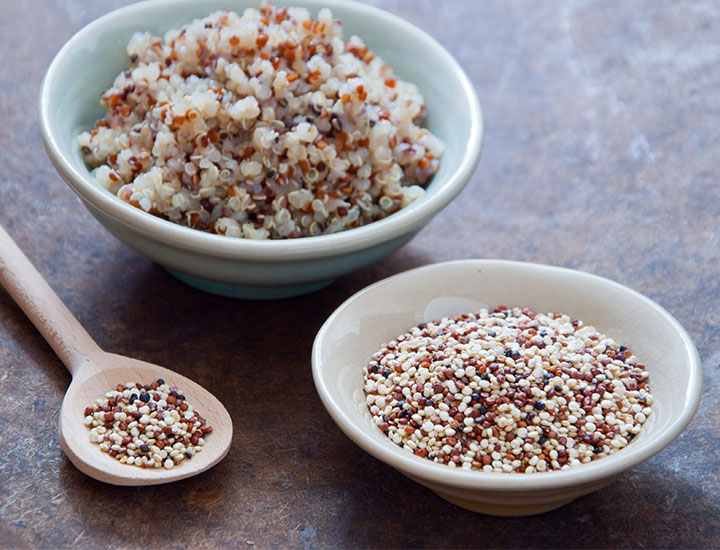 Bowls of cooked and uncooked quinoa