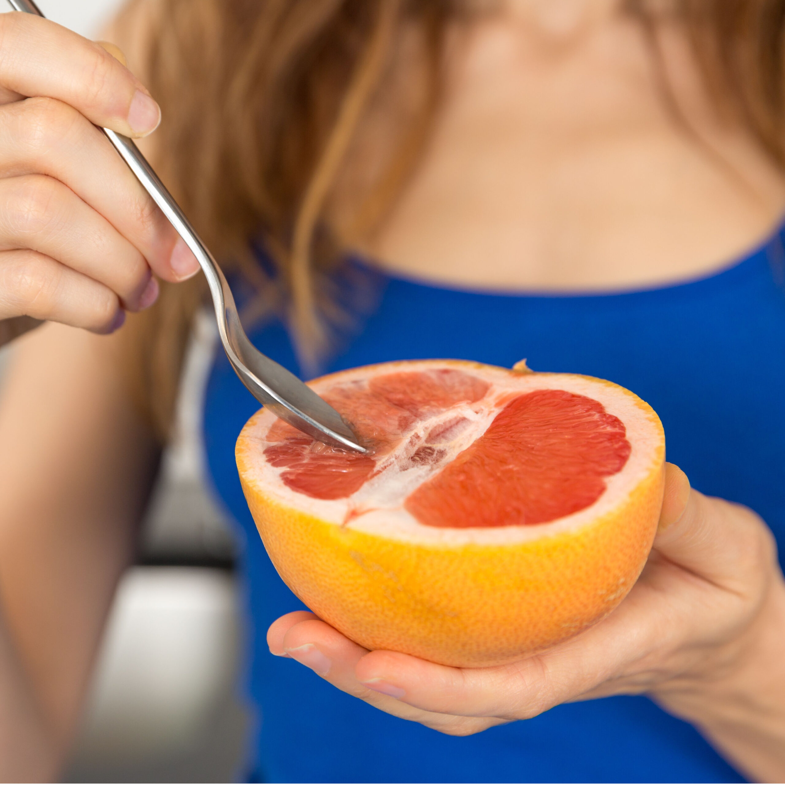 woman eating grapefruit with spoon