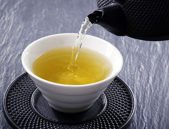 green tea pouring from a cast iron pot