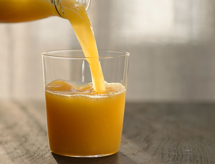 pouring a glass of orange juice