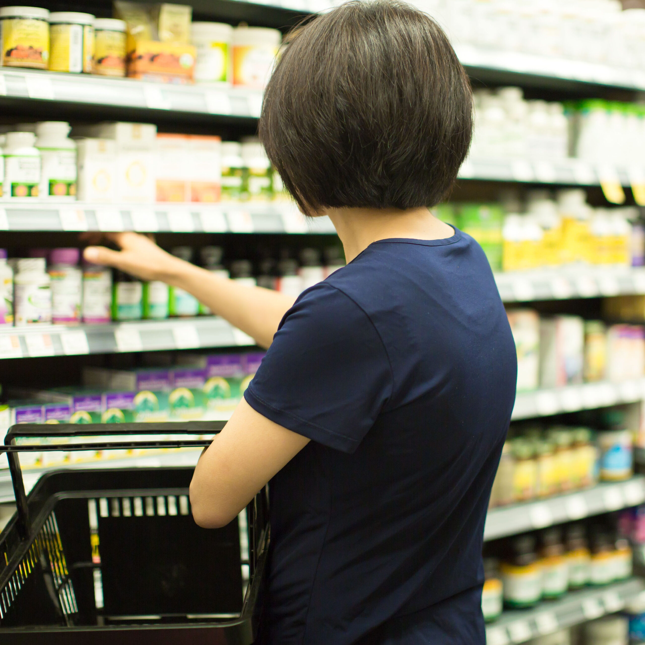 woman browsing supplement aisle