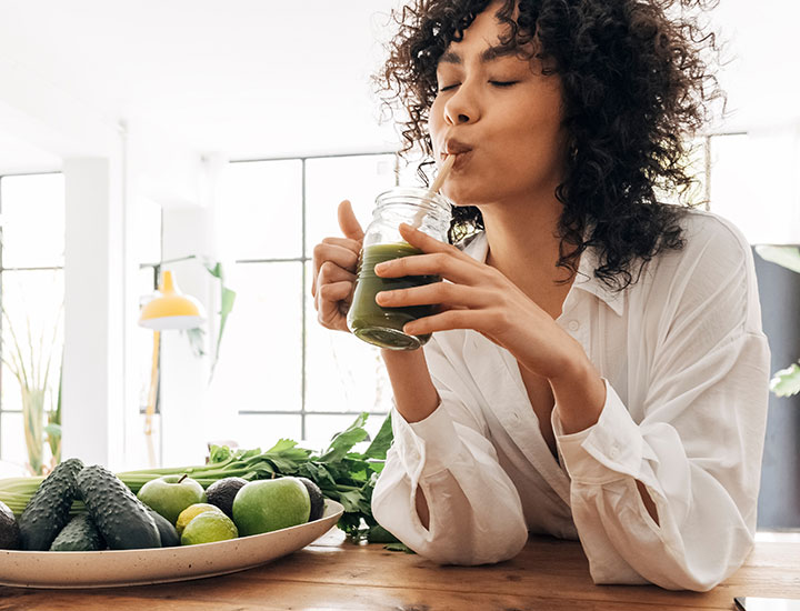 woman drinking a fresh green smoothie