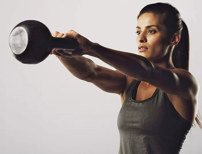 woman swinging a kettlebell