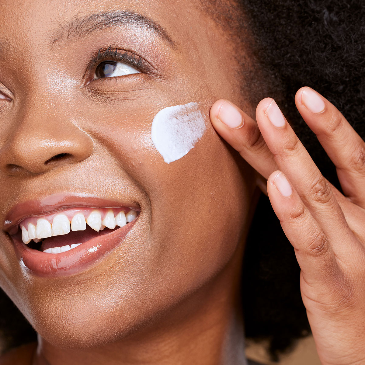 woman applying sunscreen white cosmetic cream to face moisturizer