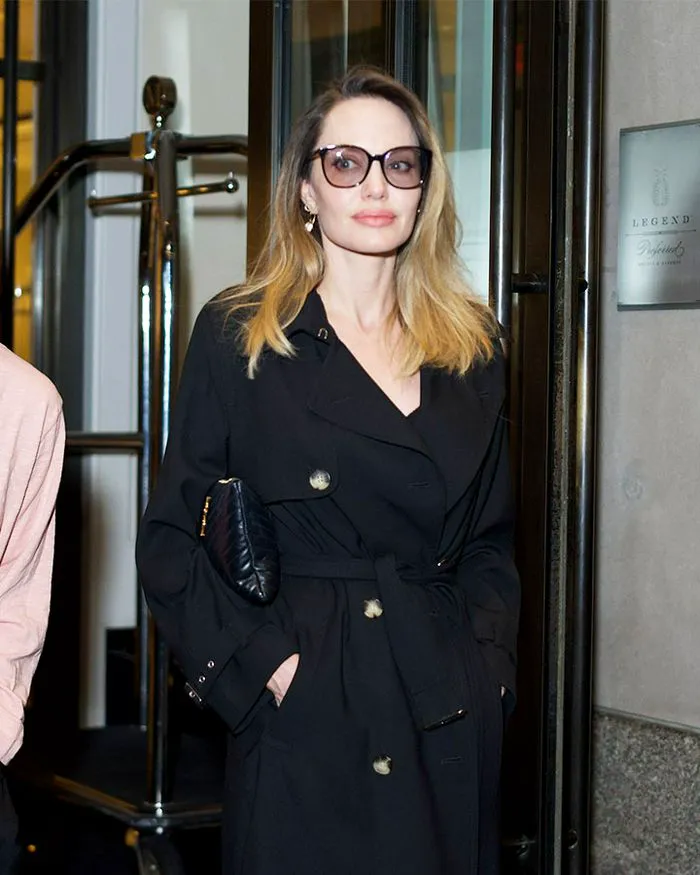 angelina jolie black trench coat belted waist sunglasses blonde hair nyc