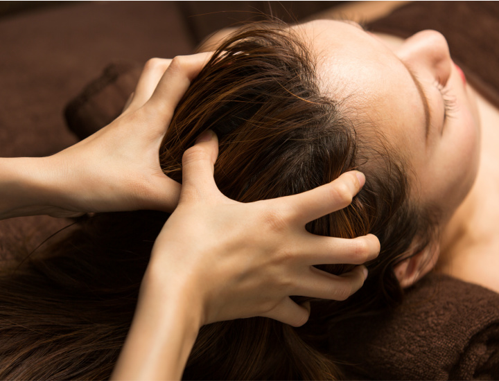 Woman massaging scalp with oils