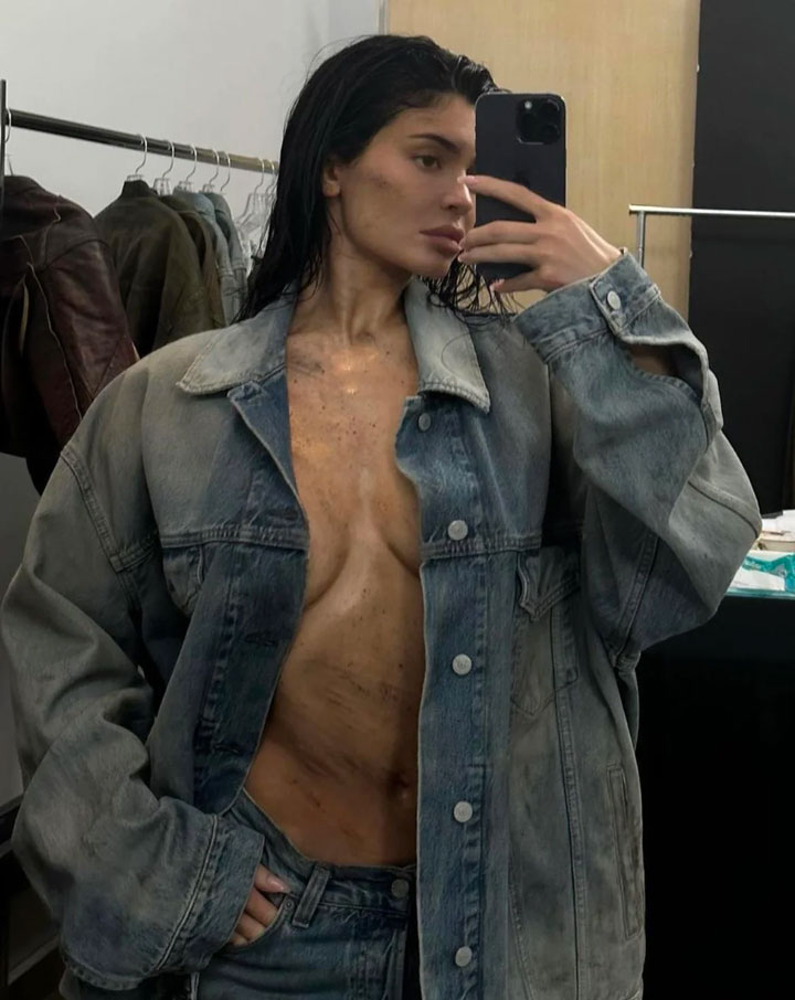 Kylie Jenner modeling for Acne Studios covered in dirt and a denim jacket, behind the scenes