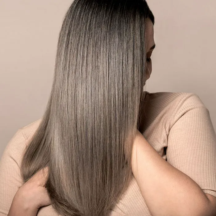 Woman proudly displaying her shiny, thick, and healthy hair.