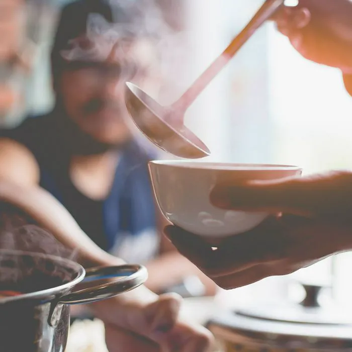person pouring soup