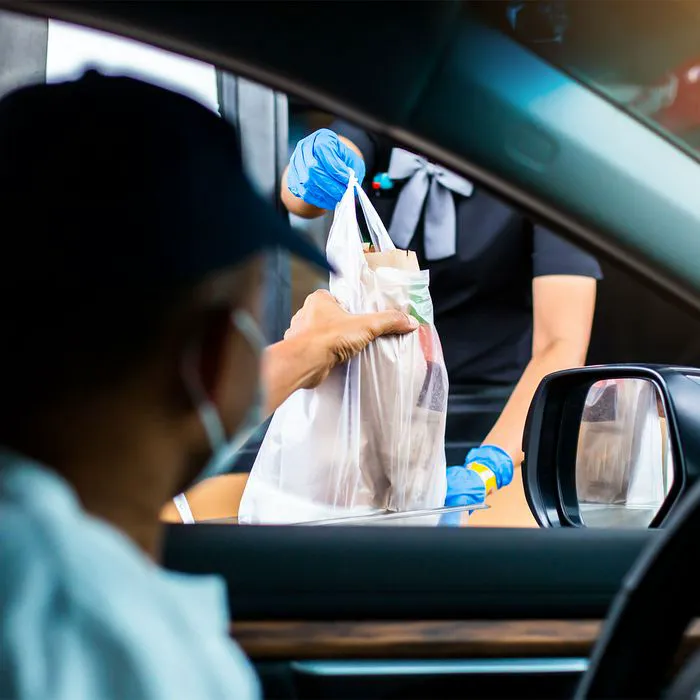 "Driver picking up fast food at window"