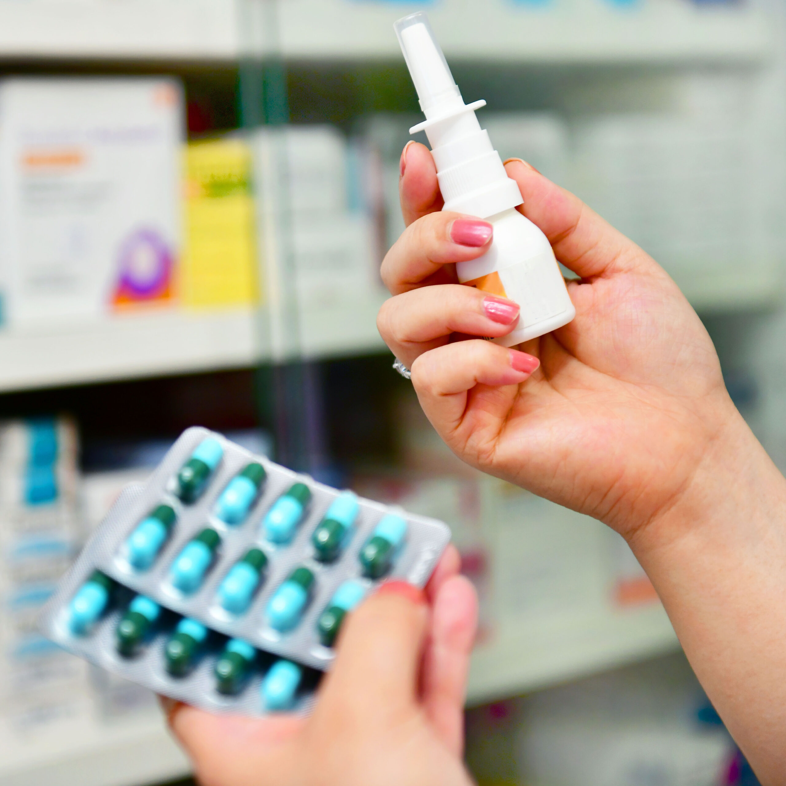 person holding sinus spray in pharmacy