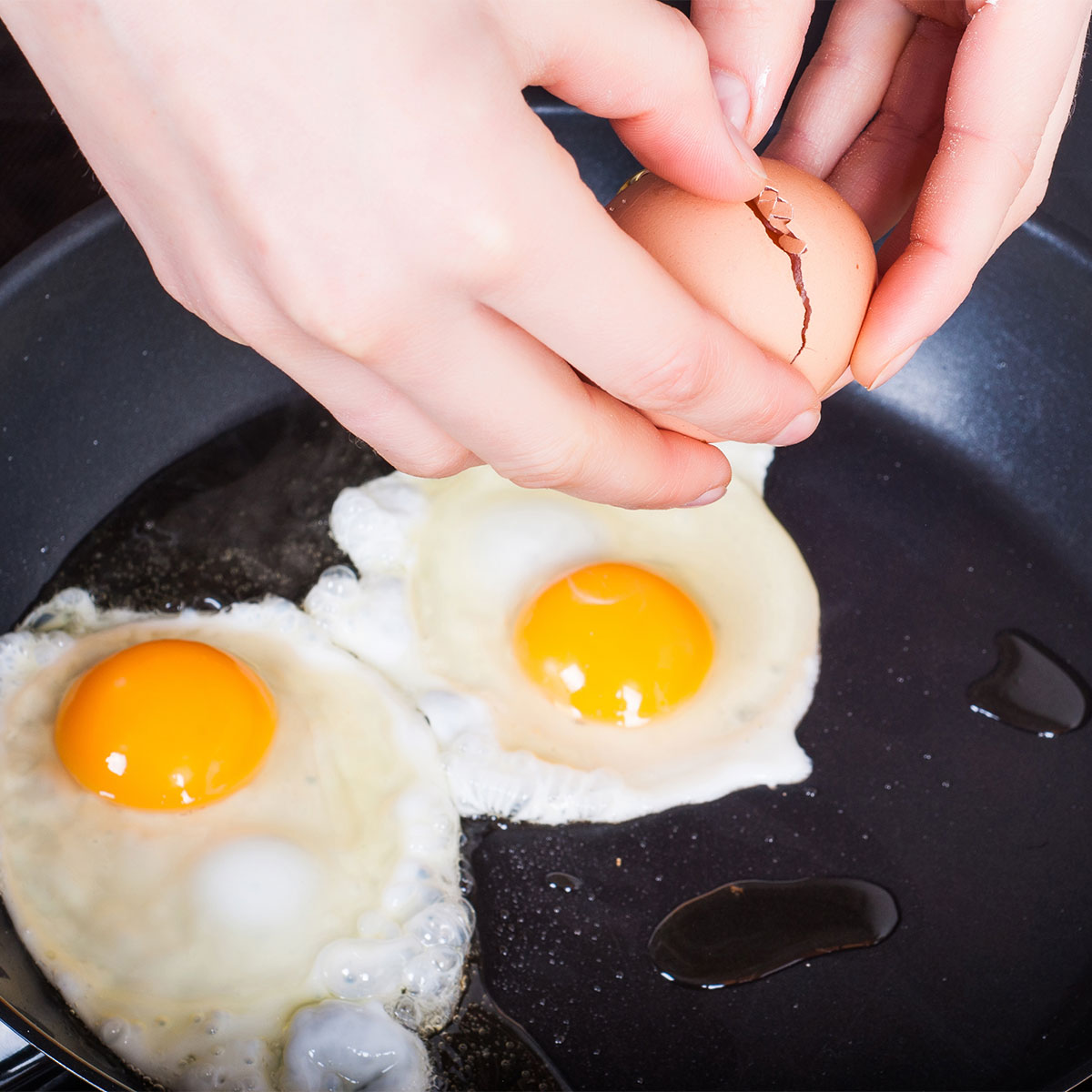 cracking eggs into skillet
