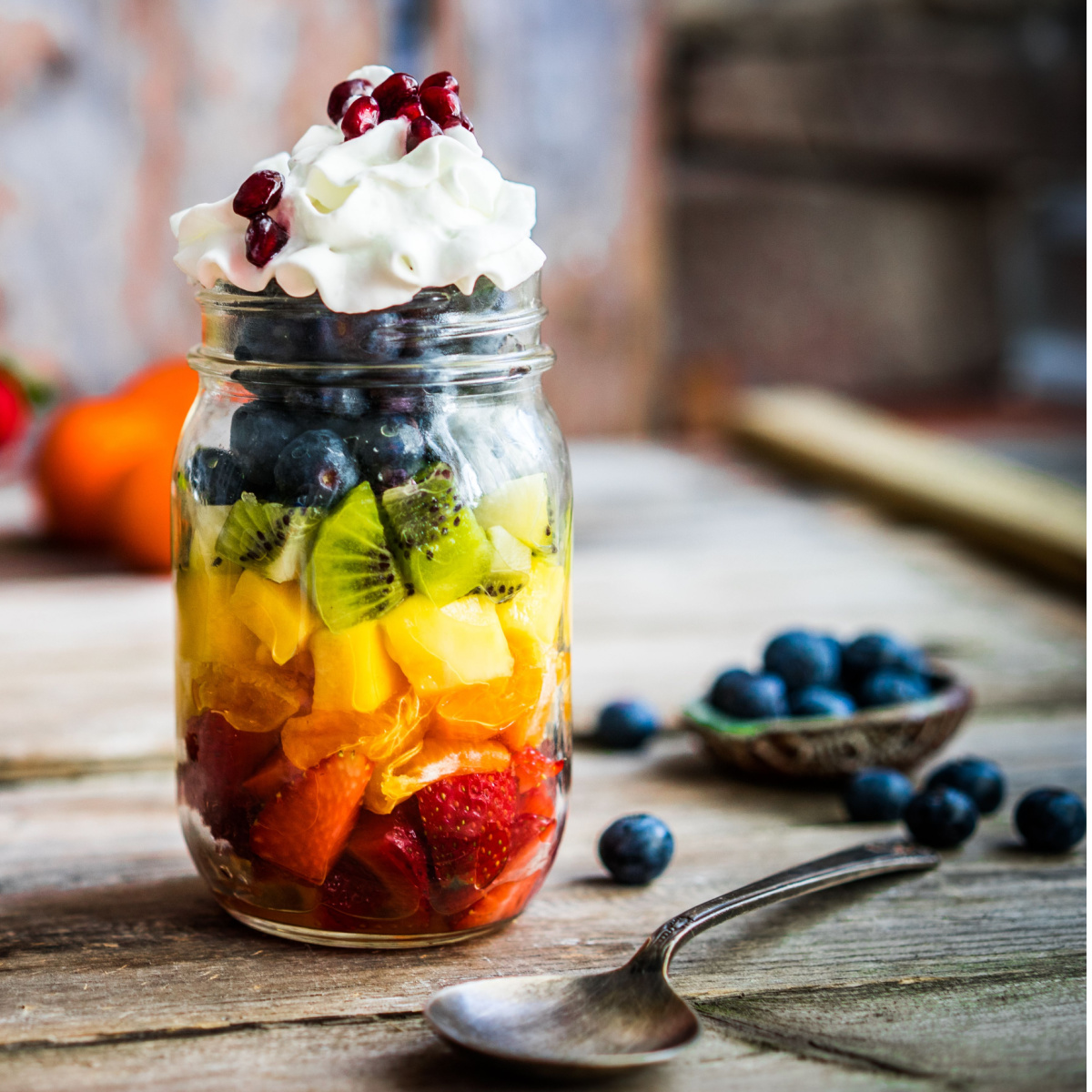 jar of fruit salad topped with whipped cream