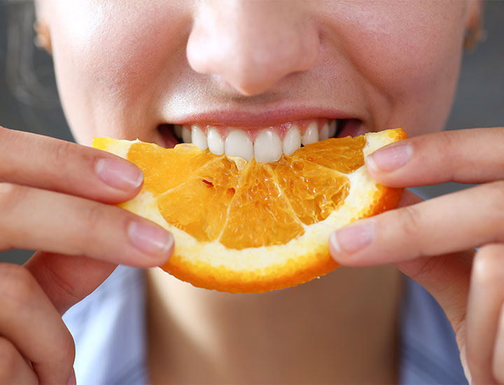 woman-eating-orange-slice