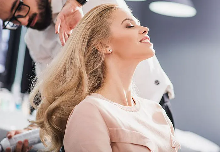 Woman with voluminous blonde hair at a salon.