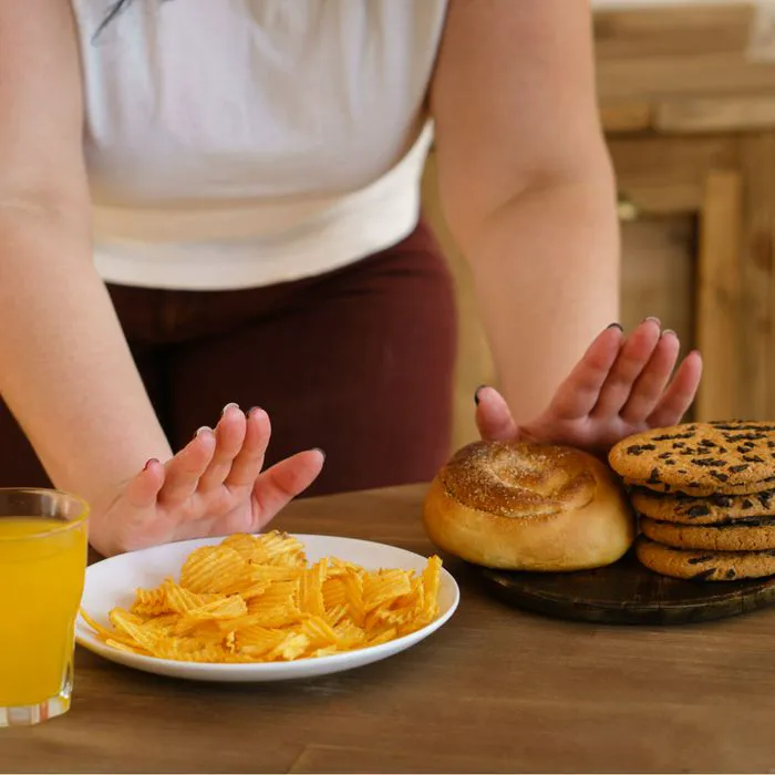 woman refusing to eat chips and bagels