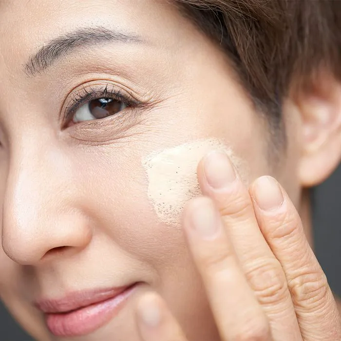 Close-up of a woman applying foundation for a flawless finish.